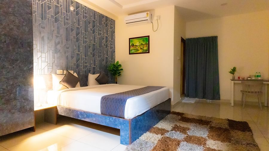 An image of a bedroom equipped with AC, wardrobe, and a table - Hotel Aerotel, Hyderabad - A Unit of Comfort Hometel