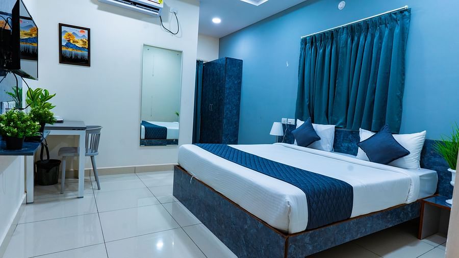An image of bedroom that has a king size bed and a wardrobe table next to it - Hotel Aerotel, Hyderabad - A Unit of Comfort Hometel