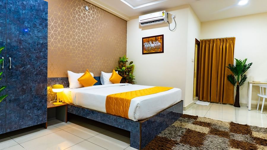An image of a bedroom equipped with AC, wardrobe, and a table - Hotel Aerotel, Hyderabad - A Unit of Comfort Hometel