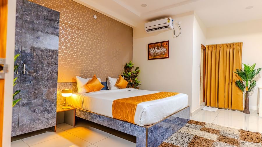 An image of a bedroom equipped with AC, wardrobe, and a table - Hotel Aerotel, Hyderabad - A Unit of Comfort Hometel