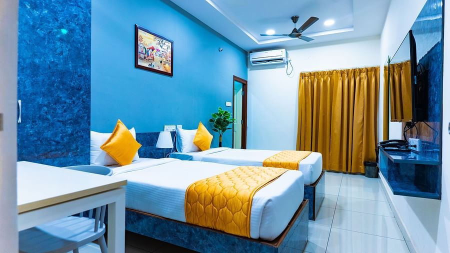 An image of a bedroom with twin bed, bedside table next to it, AC, flat TV screen, etc. - Hotel Aerotel, Hyderabad - A Unit of Comfort Hometel