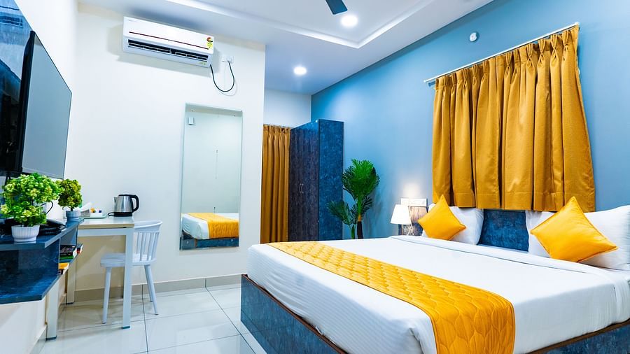 An image of a bedroom with king size bed, bedside table next to it, AC, flat TV screen, etc. - Hotel Aerotel, Hyderabad - A Unit of Comfort Hometel