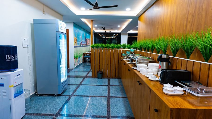 An image of a buffet area with many pots and utensils, fridge, microwave, and other kitchen appliances - Hotel Aerotel, Hyderabad - A Unit of Comfort Hometel