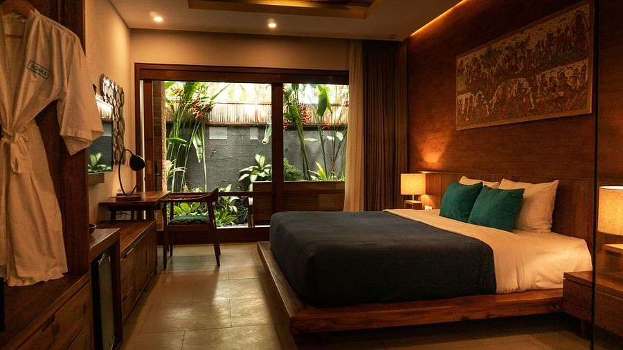 a double bed inside a room with side table and lamps next to it