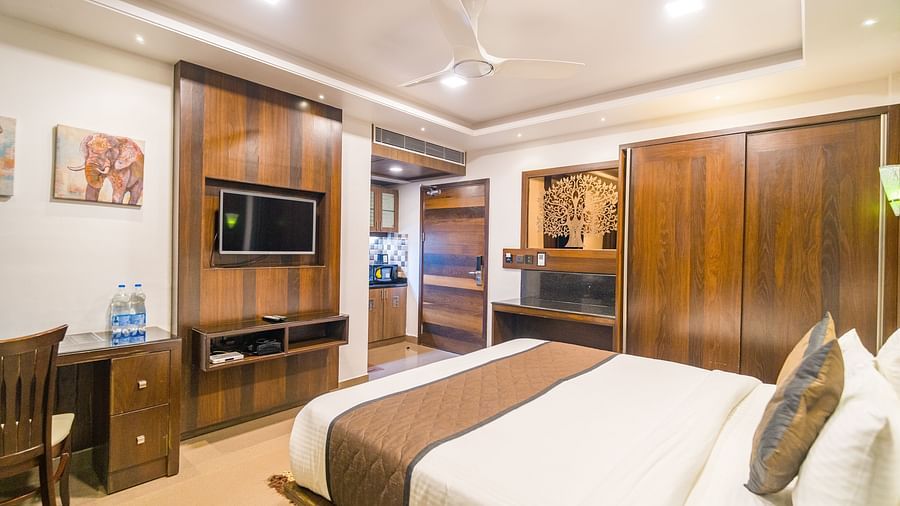 Image of room with a bed and a wooden wardrobe on the side at Hotel Altitude, Madikeri.