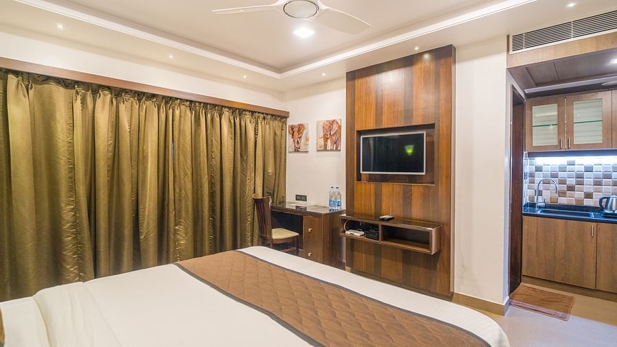 Image of a room with a bed and a door in front of it at Hotel Altitude, Madikeri.