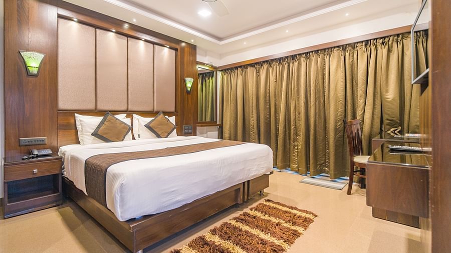 Image of a room with a bed and a rug in front of it at Hotel Altitude, Madikeri.