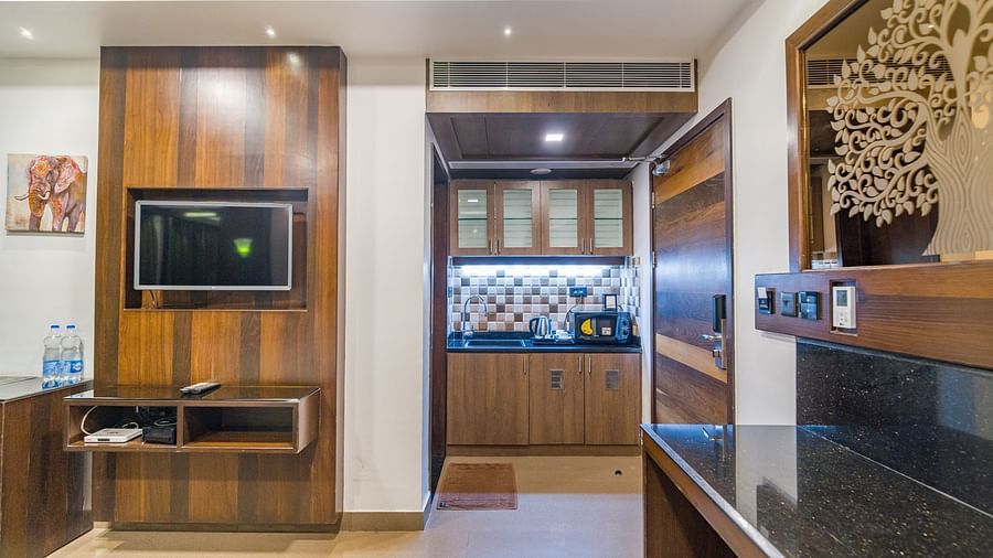 Image of a room with a television and a table on the side at Hotel Altitude, Madikeri.