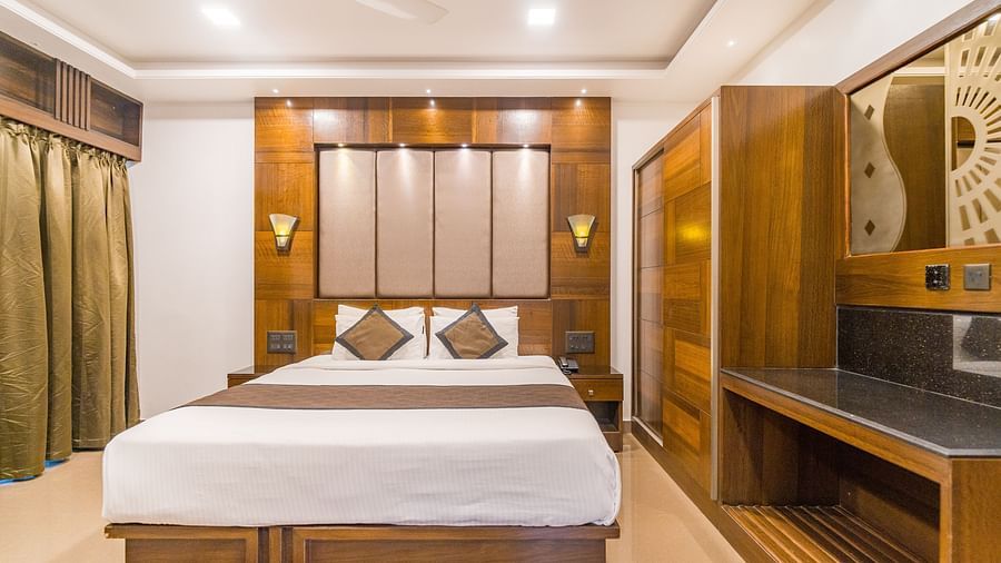 Image of a room with a bed and a window on the side at Hotel Altitude, Madikeri.