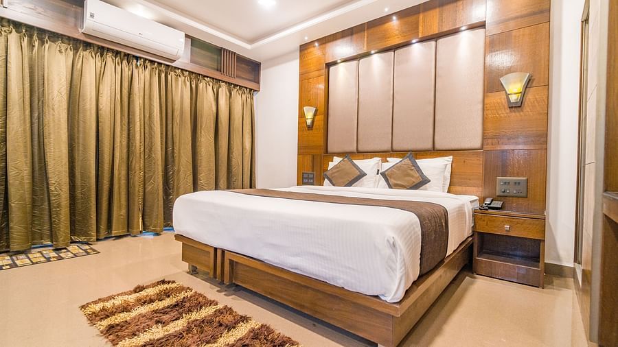 Image of a room with a bed with a rug in front of it and a window on the side at Hotel Altitude, Madikeri.