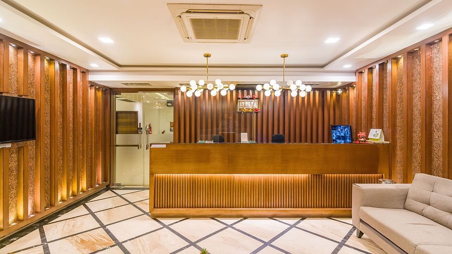 Image of a reception area with a sofa on the side and a television in front of it at Hotel Altitude, Madikeri.