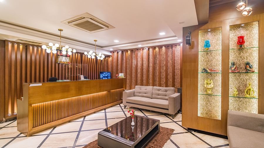 Image of a reception area with a seating area and a shelf with ornaments on display at Hotel Altitude, Madikeri.