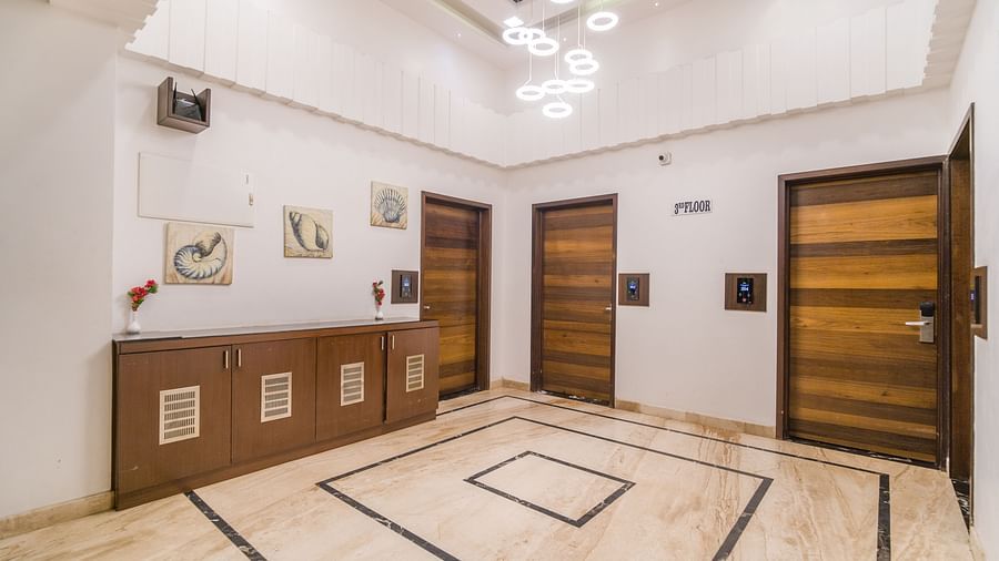 Image of a hall with four doors and a table in the corner at Hotel Altitude, Madikeri.