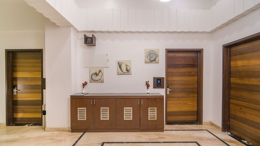 Image of a hall with three doors and lights on the ceiling at Hotel Altitude, Madikeri.