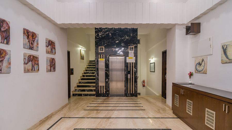 Image of a hallway with a table on the side and a staircase in front at Hotel Altitude, Madikeri.