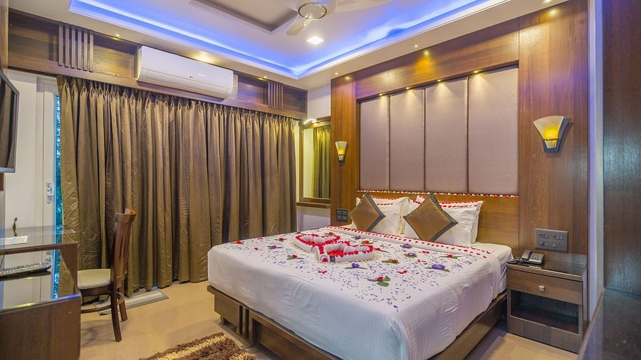 Image of a room with a bed decorated with flower petals at Hotel Altitude, Madikeri.