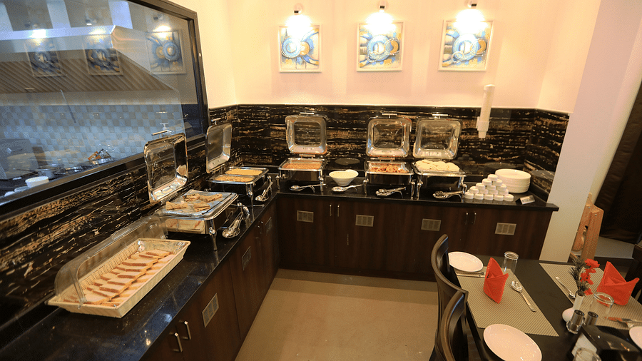 A buffet table with food placed on it at Hotel Altitude, Madikeri.