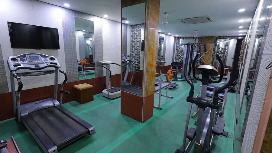 Image of a gym at Hotel Amar with gym equipment and a mirror 
