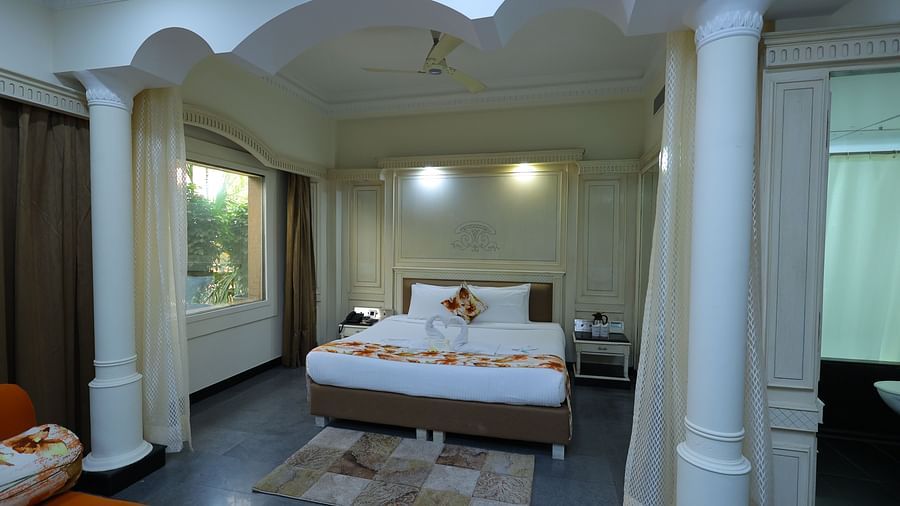overview  image of a Suite at Amar Hotel with a bed, table, sofa and a window