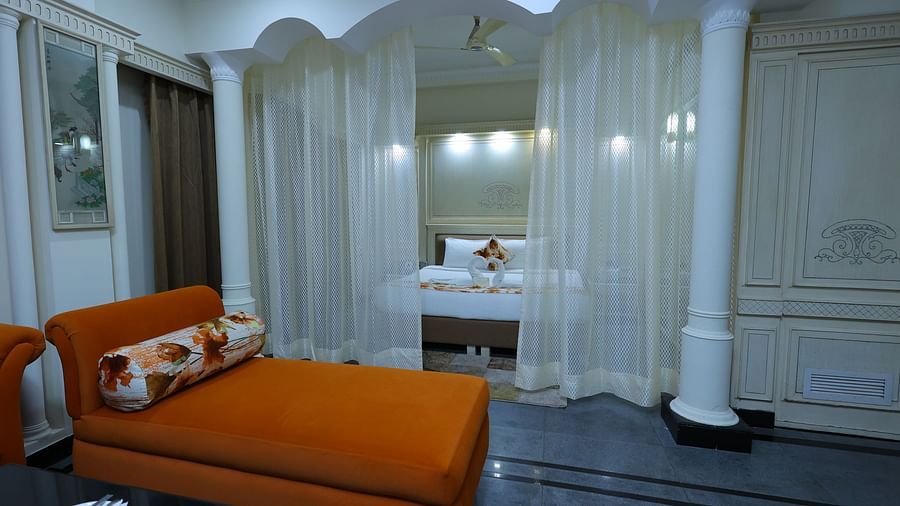 Closeup image of a Suite at Amar Hotel with a sofa, table, and a curtains