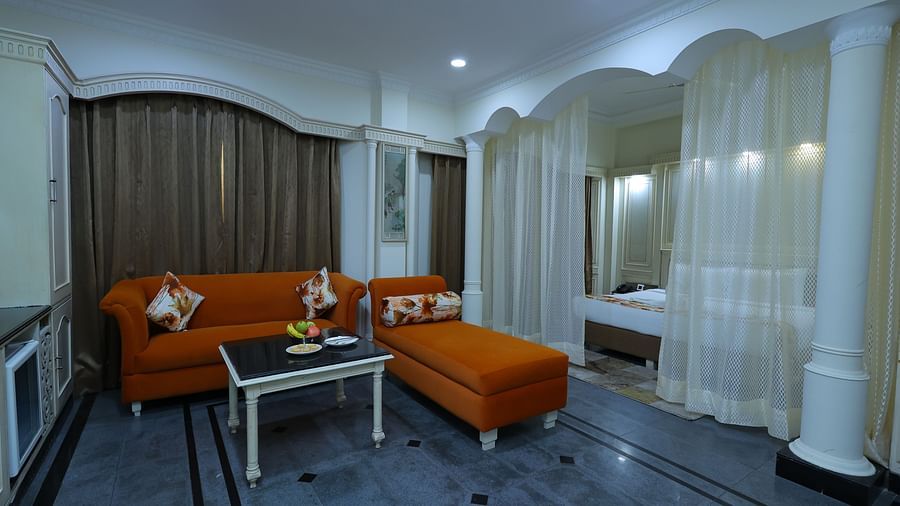 Overview image of a Suite at Amar Hotel with a sofa, table, and a curtains