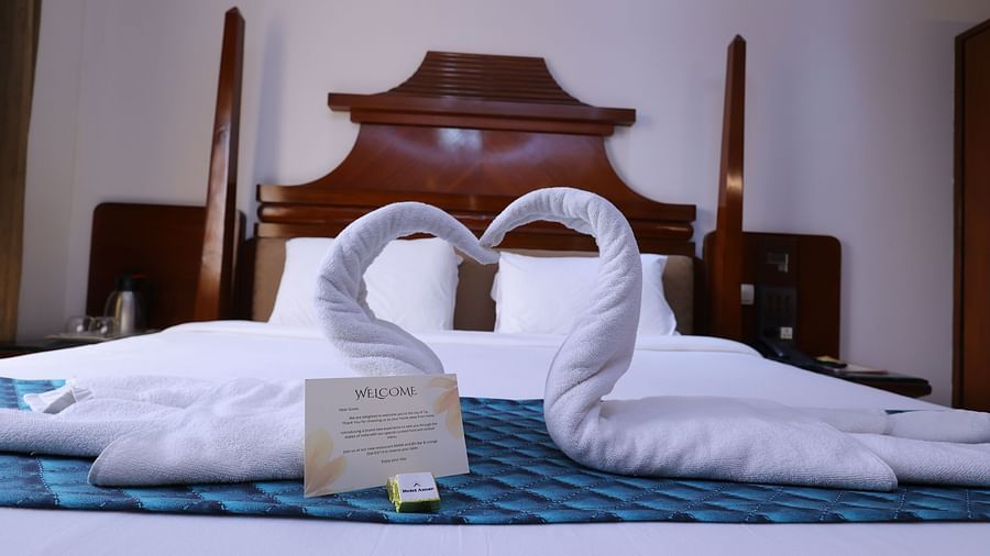Image of a Premium room at Hotel Amar with towels shaped as swans kept on the bed 