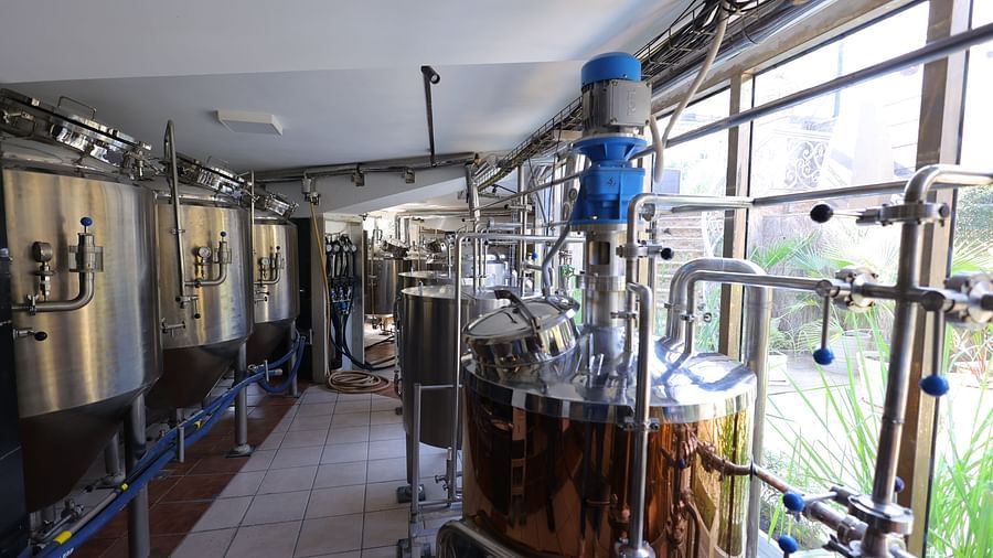 Image of a brewery setup at Hotel Amar with huge gold and steel containers.