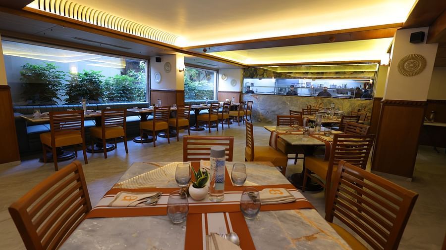 Close up image of Anam restaurant of Hotel Amar with chairs and tables arranged 