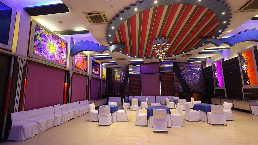overview image of Amar Mahal of hotel Amar with cluster seating arrangement  and lavish decoration 