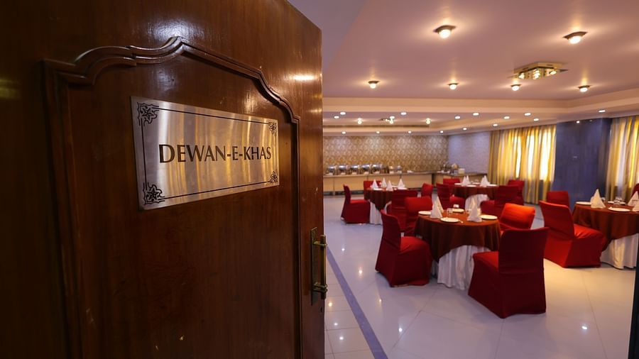 Entrance of Dewaane-e-khas hall of Hotel Amar with red chairs and cluster seating arrangement 