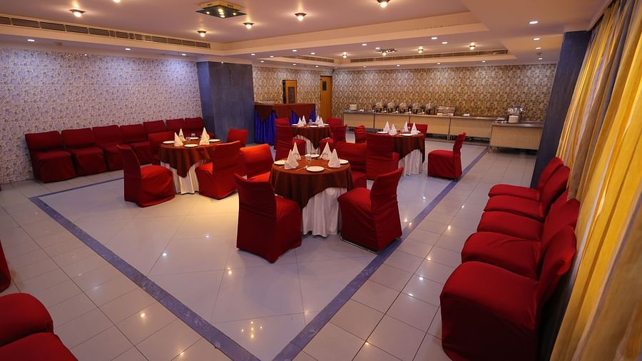 Image of Dewaane-e-khas hall of Hotel Amar with red chairs and cluster seating arrangement 