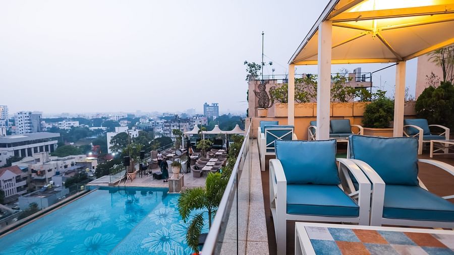 An outdoor dining space next to a pool at Hotel Ashok Nagpur.