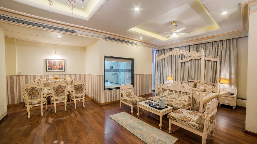 King Suite featuring ornate furniture, warm lighting, and a plush rug.- Hotel Ashok Nagpur