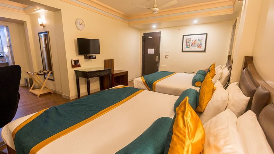 Family Room featuring two large beds facing the TV. - Hotel Ashok Nagpur