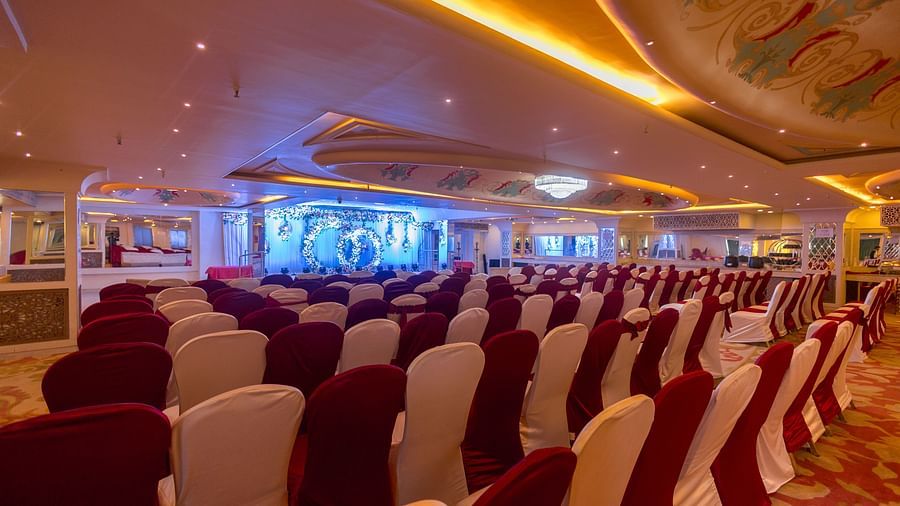 Samrat featuring rows of chairs arranged facing a stage with a screen.