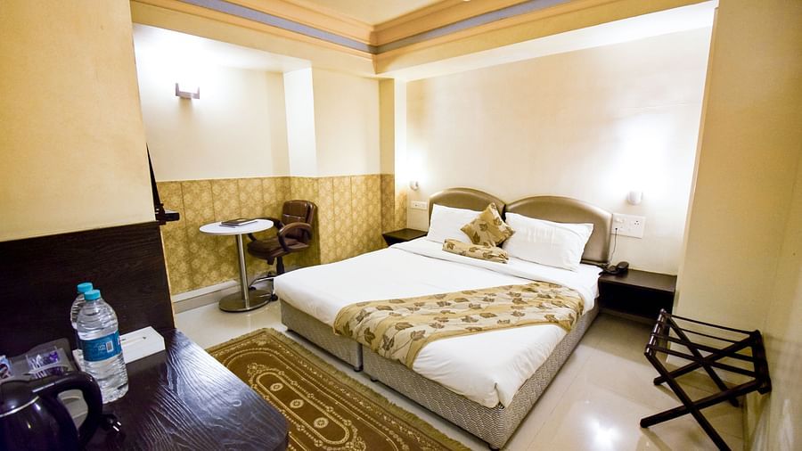 A large bed placed surrounded by interior decor in Economy Room at Hotel Ashok Nagpur.