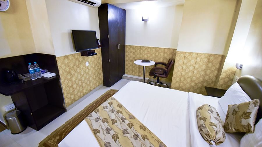 Side view from the bed of Economy Room featuring the television and a wardrobe. - Hotel Ashok Nagpur