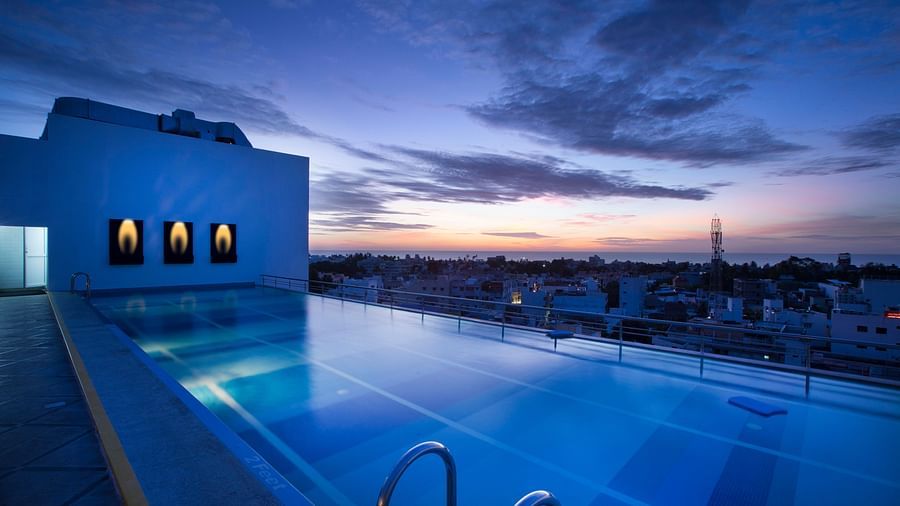 view of a swimming pool at sunset at Hotel Atithi - TGI Grand, Pondicherry
