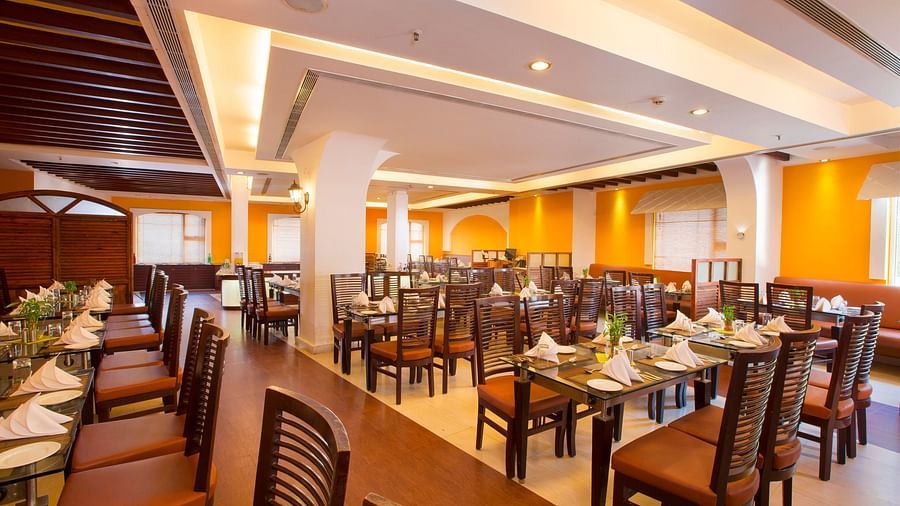 rows of chairs and table placed in a dining table at Hotel Atithi - TGI Grand, Pondicherry