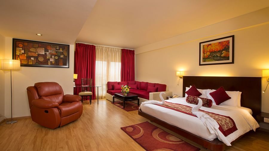 Family Suite decked with a bed, a sofa and a recliner overlooking a window at Logo of Hotel Atithi - TGI Grand, Pondicherry
