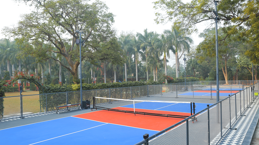 Side view of pickleball court with safety fencing at Hotel Clarks Shiraz, Agra.