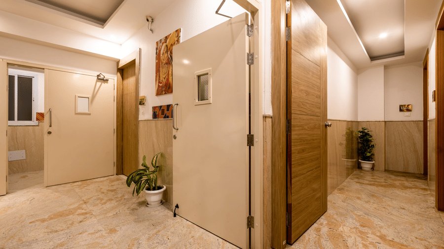 A door opening into a hallway featuring marble flooring and a warm light at Hotel Corporate Suites