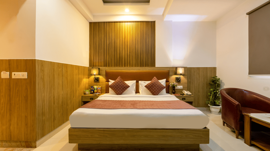 Deluxe Room featuring a double bed next to a seating space under war lighting at Hotel Corporate Suites