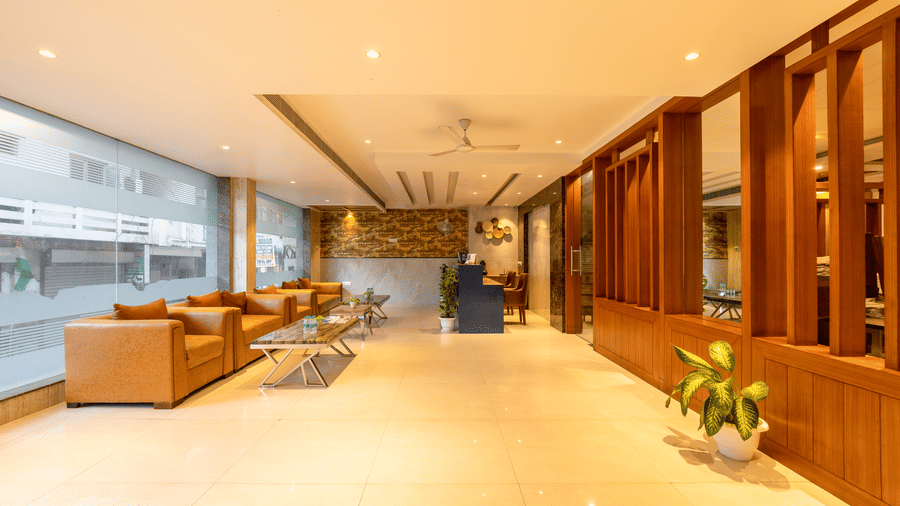 Reception area with blue accents and comfortable leather seating against glass floor-to-ceiling windows for all guests at Hotel Corporate Suites