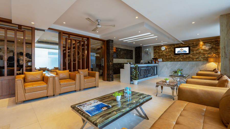 Reception area at Hotel Corporate Suites with its polished floors, wooden screens, and plush seating arrangements