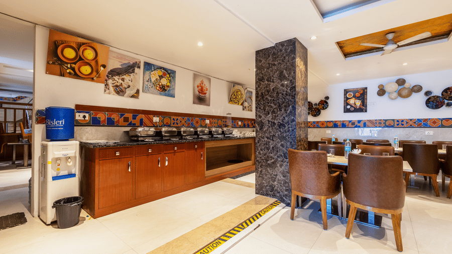 Teh Curry House featuring dining setting with polished floors, a large central table, and a buffet area at Hotel Corporate Suites