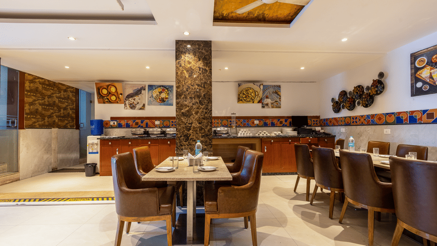 The Curry House featuring brown chairs, polished tables, marble columns, and colourful tiled accents at Hotel Corporate Suites