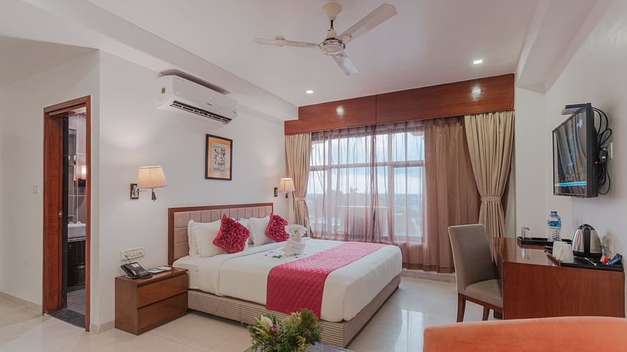 Comfortable hotel room at Diamond Palace Lords Plaza with a double bed, seating area, mounted TV, and air conditioning.