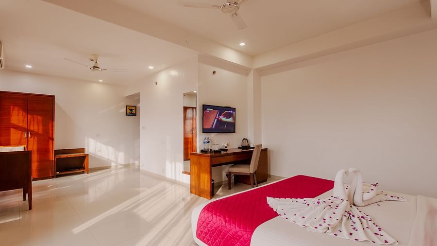 Spacious hotel room at Diamond Palace Lords Plaza featuring a double bed with colorful accents and a dedicated work area.