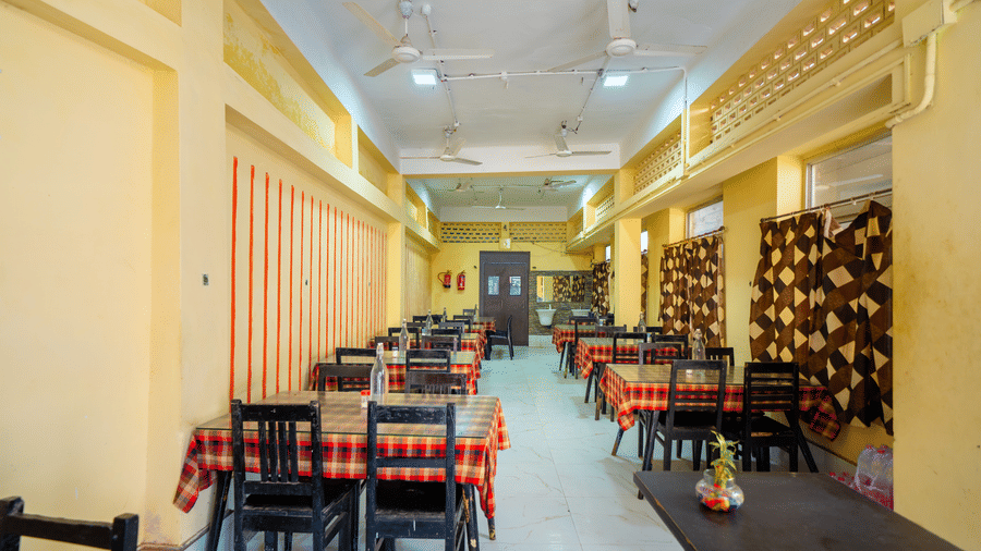Hotel dining hall showing multiple tables set up under overhead ceiling fans - Hotel Dolphin Puri